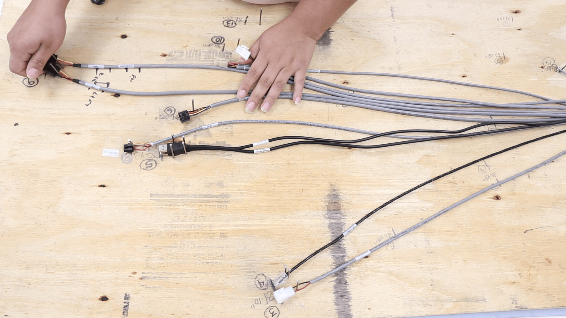 Cables being laid out on plywood board.